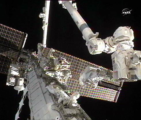 Astronautas Doug Wheelock  e Tracy Caldwell Dyson consertando a Estação Espacial