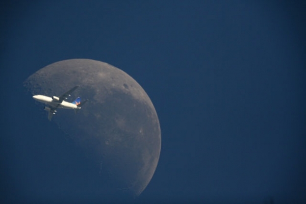 Avião cruzando a lua