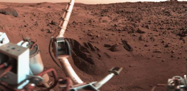 Sonda Viking 1 utiliza o braço robótico para coletar amostras de solo. Experimentos posteriores teriam indicado a presença de microbios em Marte. 