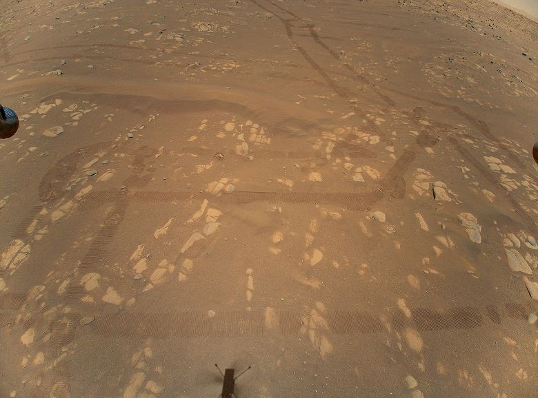 Foto aérea de Marte, feita em 22 de abril de 2021 pelo drone Ingenuity, mostra a superfície do planeta e as marcas deixadas pelo rover Perseverance. 