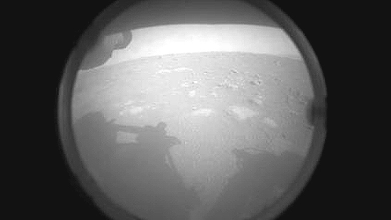 Primeira foto enviada pela Mars Perseverance quatro minutos após o pouso. No horizonte temos a borda cratera Jezero.