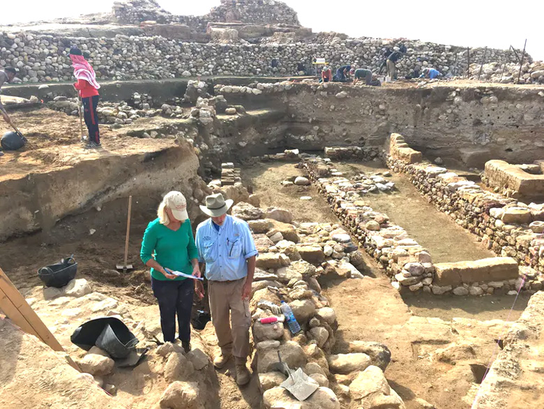 Pesquisadores trabalham prximo s runas das antigas muralhas da cidade de Tall el-Hammam runas, com as camadas de destruio ligeiramente abaixo de cada muralha exposta. Crdito: Phil Silvia.<BR>