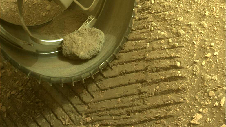 Rocha marciana presa à roda do jipe Perseverance, fotografada em 26 de maio 2022. Crédito: NASA/JPL/Caltech<BR>